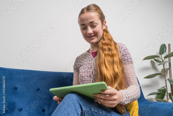 Obraz Young woman with dental braces smiling while chatting online in tablet