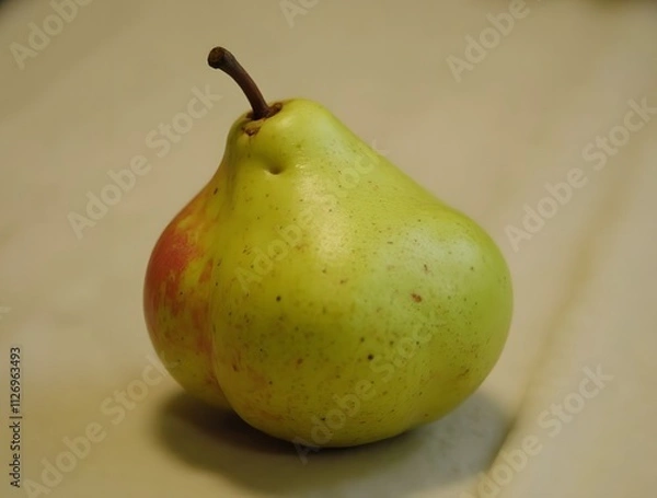 Fototapeta A Single Ripe Pear on a Beige Background