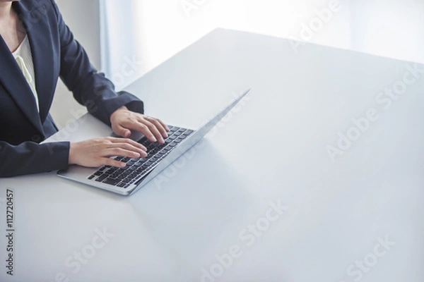 Obraz パソコンで作業するビジネスウーマンの手元