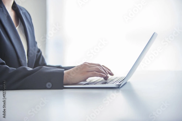 Obraz パソコンで作業するビジネスウーマンの手元