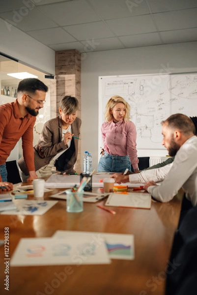 Fototapeta Marketing professionals collaborating on project in modern office