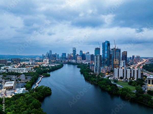 Obraz Aerial view of Austin, Texas skyline at dusk, showcasing modern skyscrapers reflecting on the Colorado River under a dramatic cloudy sky