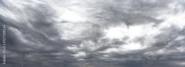 Fototapeta Panorama of gray cloud filled rain sky with local transparent areas

