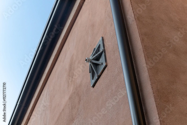 Fototapeta Tie rod on exposed building wall on the facade of the building, with construction detail of the support keys of the internal tie rods, key - counter-thrust chain for a renovated building. detail