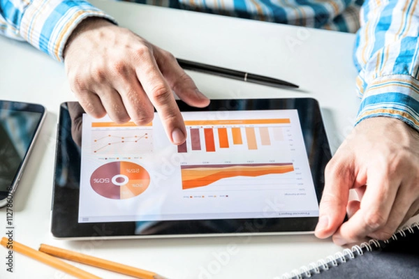 Fototapeta Businessman working with digital Tablet computer with finance report in Office. Business market Research, Economic statistics concept