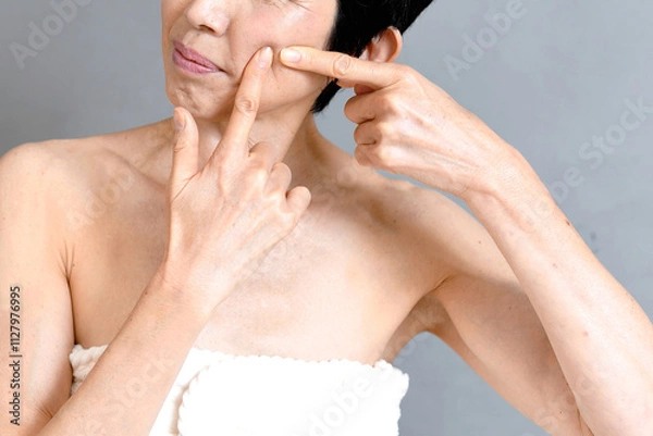 Obraz 頬に指を指す笑顔の中年のアジア人女性