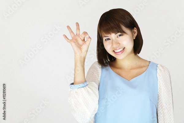 Fototapeta オーケーサインをする若い女性
