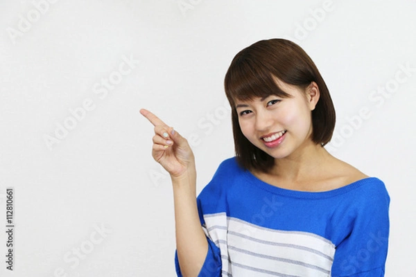 Fototapeta 指を差す若い女性