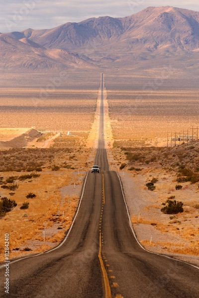 Obraz Długa pustynna autostrada prowadząca do Parku Narodowego Doliny Śmierci z Beatty w Nevadzie