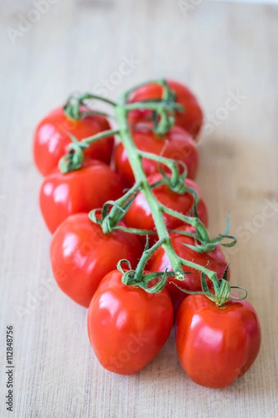 Fototapeta Top view of fresh tomatoes on a wooden desk. Macro shot of bright red tomatoes. Selective focus.