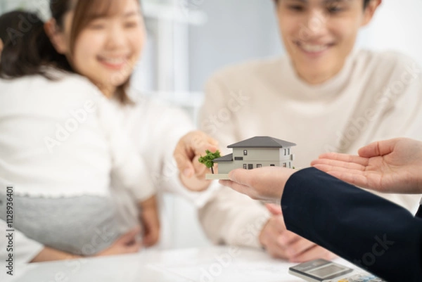 Obraz 家の模型を持って設計の話をするビジネスウーマン