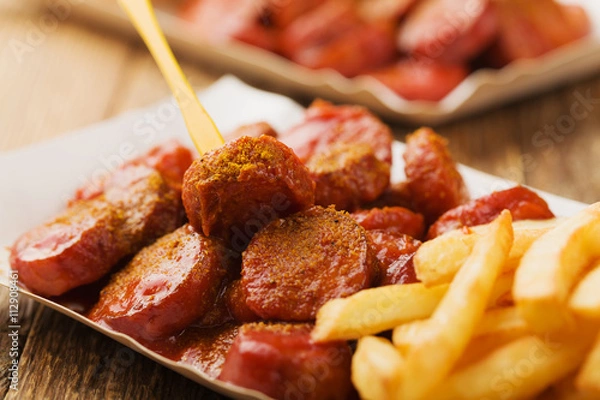 Obraz Tradycyjny niemiecki currywurst, podawany z frytkami na jednorazowym p