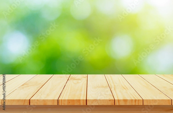 Fototapeta Wood floor with blurred trees of nature park background and summer season, product display montage