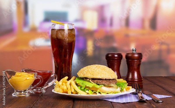Fototapeta Hamburger, french fries, glass cola, sauces, spices on background cafe.