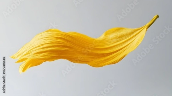Obraz A yellow sunflower petal floating mid-air over a soft gray background.