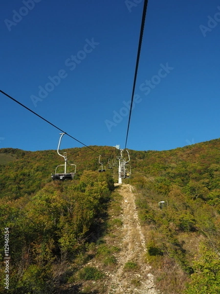 Obraz Cable car in the mountains on a background of blue sky.
