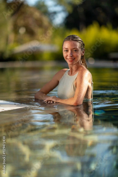 Fototapeta  A stylish woman posing confidently in a luxurious pool, surrounded by a serene and relaxing summer atmosphere.