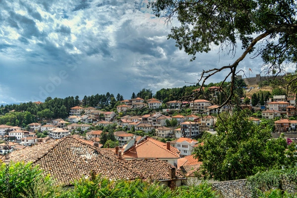 Fototapeta Historical part of old town Ohrid is located next to the lake and spread all over the hill with fortress of king Samuel at the top.  Dramatic clouds in the sky.
