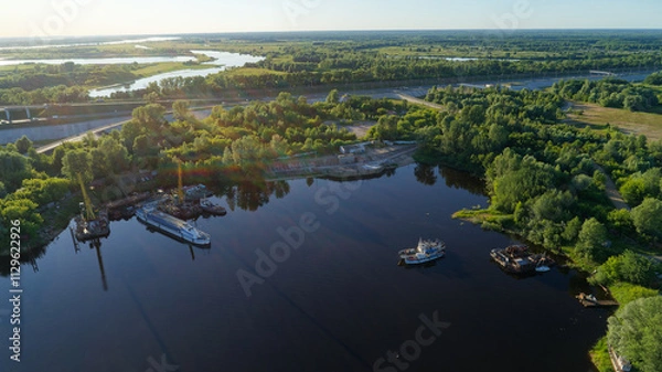 Fototapeta Large body of water with a few boats floating on it