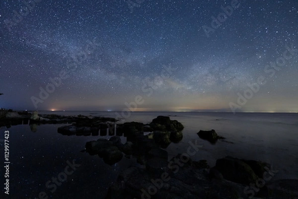 Fototapeta 海岸の水面に輝く星々と能登半島の星空