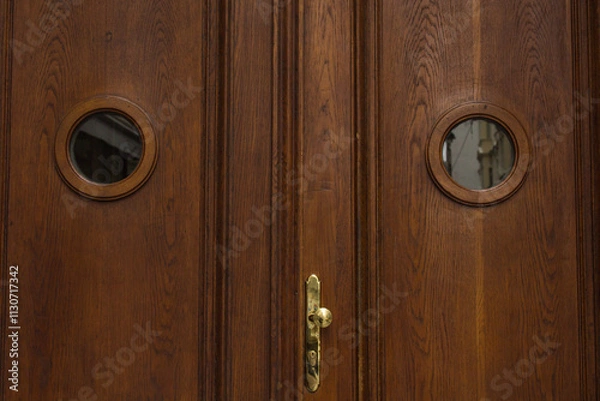 Obraz Vienna, Austria - May 12, 2019: Wooden doors front view. Vintage wooden large double barn door with brown wood texture and metallic handle, closeup photo.