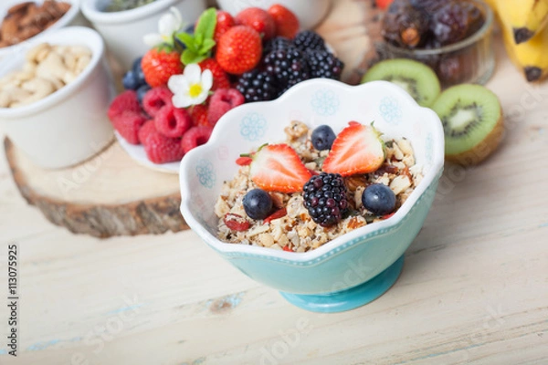 Fototapeta Paleo style breakfast: gluten free grain free oat free granola with mixed nuts, and fresh berries and fruits, selective focus
