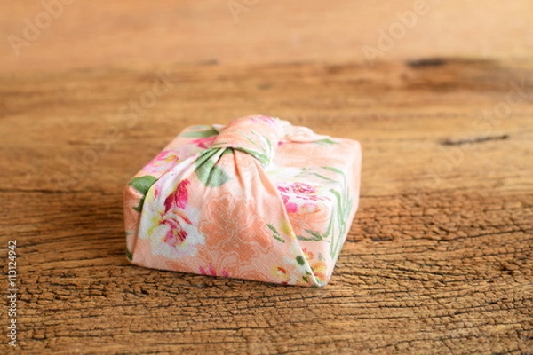Obraz Gift box wrapped with Thai traditional style cloth tie on wood background