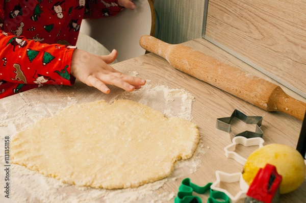 Fototapeta Cute caucasian boy in red pijamas making cookies in the kitchen