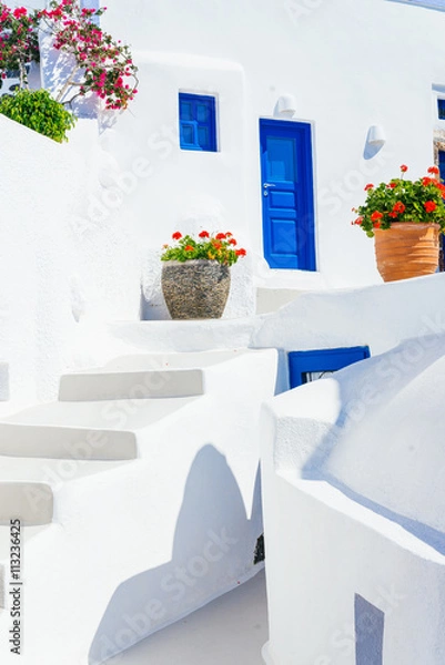 Obraz Traditional cycladic whitewashed architecture with blue doors and flower pots, Imerovigli, Santorini island, Greece