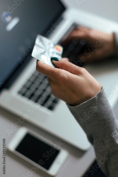 Fototapeta Person shopping making Payment at Computer using Credit Card