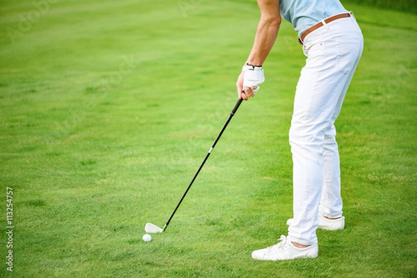 Fototapeta Close up of man playing golf on course