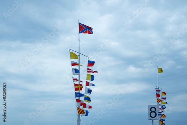 Fototapeta Nautical flags on the pier against the sky