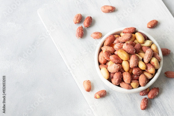 Fototapeta Roasted salty peanut without Shell in bowl or burlap sack on rustic background, concept of nuts