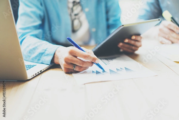 Fototapeta Photo Sales Manager Working Modern Office.Woman Use Generic Design Tablet,Holding Pencil Hand.Account Department Work process New Startup project.Wood Table.Horizontal.Blurred Background.Film effect.