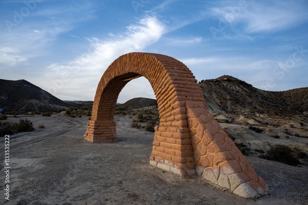 Fototapeta Historic Brick Archway in Desert Landscape: A Freestanding Reddish-Brown Structure Amidst Rolling Arid Hills, Capturing the Unique Blend of Human-Made Architecture and Natural Desert Beauty