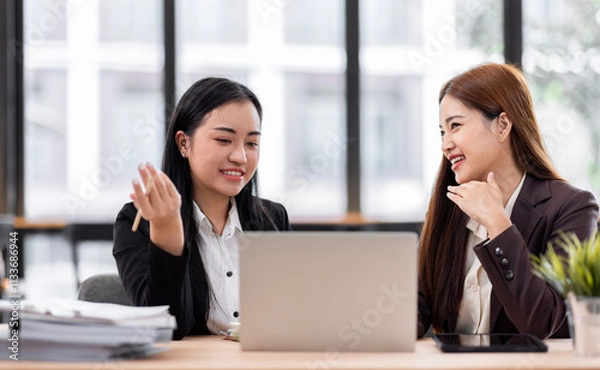 Fototapeta Business financing accounting banking concept. Two asian Business doing finances and calculate on desk about cost at workplace. Business working on desk with using calculator, finance accounting.
