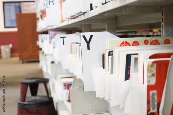 Fototapeta Held books for self pickup on shelves in library