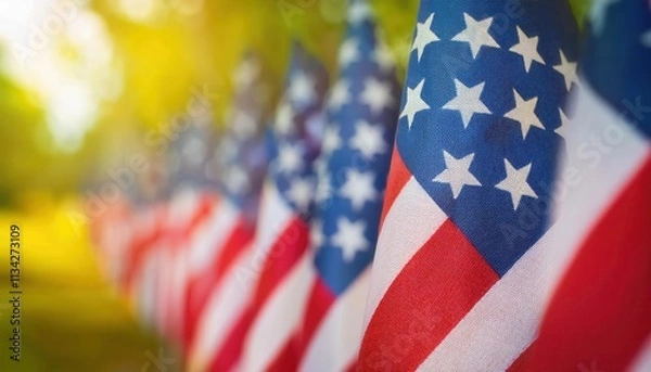 Fototapeta Close-Up View of Vibrant American Flags Waving Outdoors on a Sunny Day with Golden Light and Greenery in the Background. Perfect for Celebrating Patriotic USA Holidays, Memorial Day, or July 4th Event