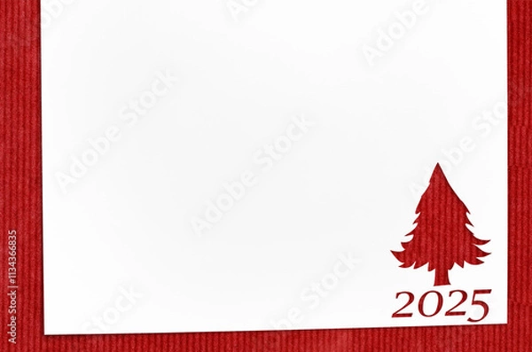 Obraz Christmas 2025 background. White paper with fir-tree shape cut for new year 2025 card on wooden table
