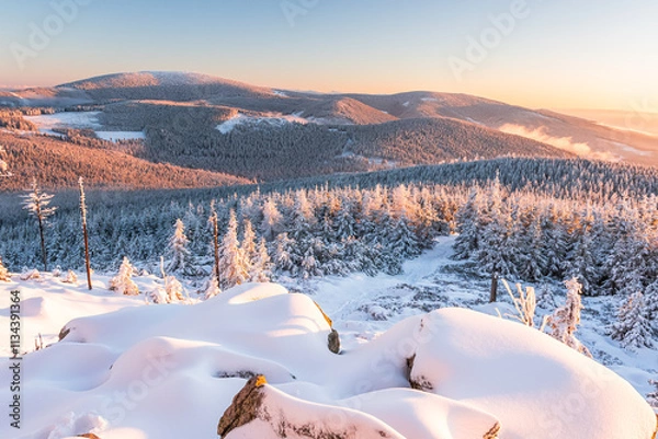 Fototapeta Eastern Sudetes, View of snowy mountain range from hiking trail during winter hike in the mountains, viewpoint of wide winter landscape in the mountains at sunset.