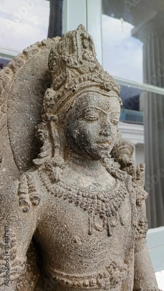 Fototapeta Close-up of a detailed stone statue of a serene Hindu deity, showcasing intricate carvings and textures