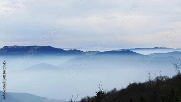 Fototapeta Serene Landscape of Mist-Covered Mountain Ranges 