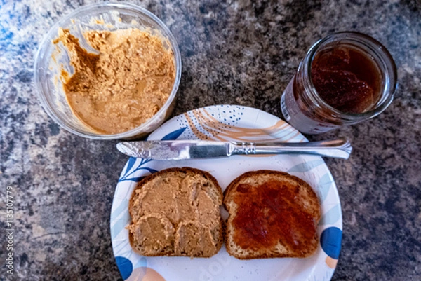 Fototapeta top down open face peanut butter and jelly sandwich on paper plate