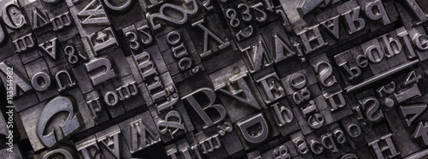 Obraz Typy druków metalowych.
Tło z wielu historycznych liter typograficznych w czerni i bieli z białym tłem.