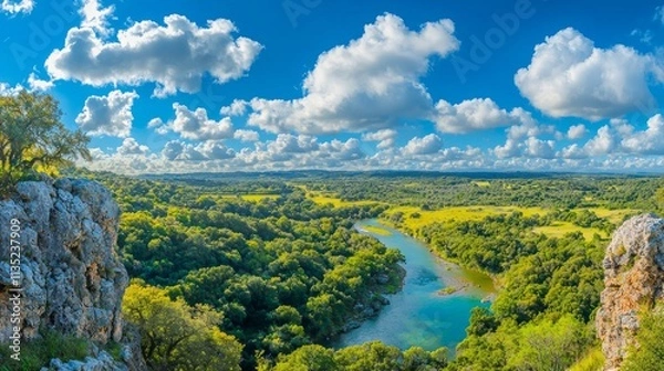 Fototapeta A panoramic view of a lush landscape with a winding river and blue sky.