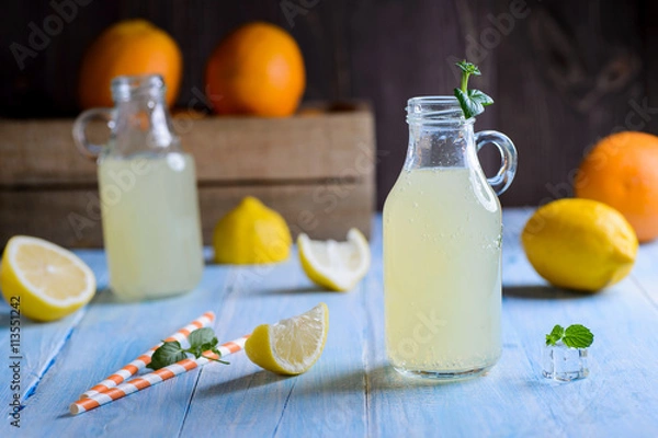 Obraz Ice cold citrus lemonade on wooden table on natural background
