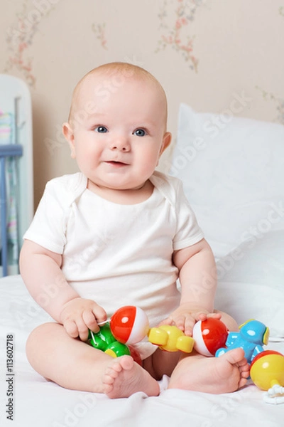 Fototapeta Cute smiling baby laughing and smiling with a toy in his hand. L