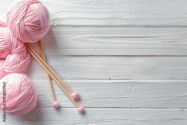 Obraz A wooden table with a pink ball of yarn and two knitting needles