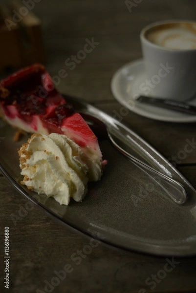 Fototapeta kuchenstück mit sahne und einem kaffee im hintergrund