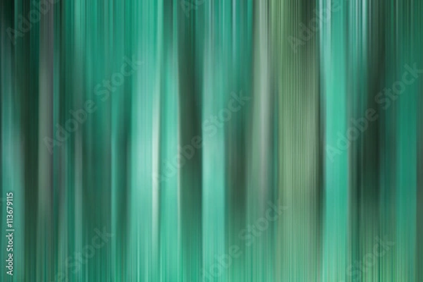 Fototapeta Abstract art for background use. An image of a forest processed with a motion blur effect. The color tone is turquoise.
